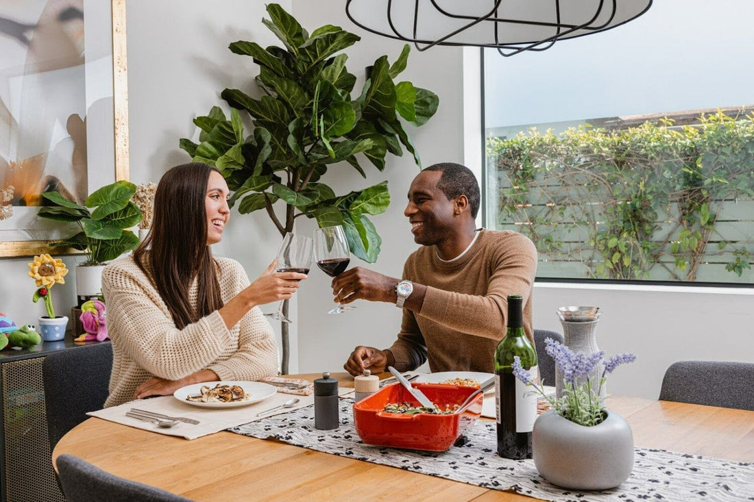 two people cheers wine glasses over a dinner date