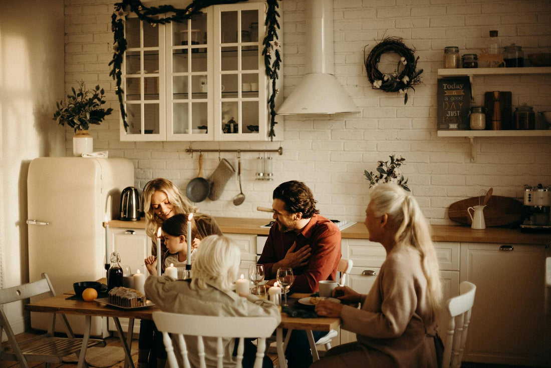 A multigenerational family gathers eats in a kitchen with rustic chic winter decor