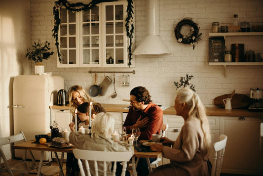 A multigenerational family gathers eats in a kitchen with rustic chic winter decor