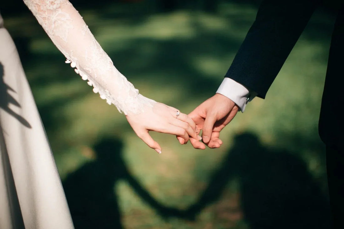 Close-up of bride and groom holding hands