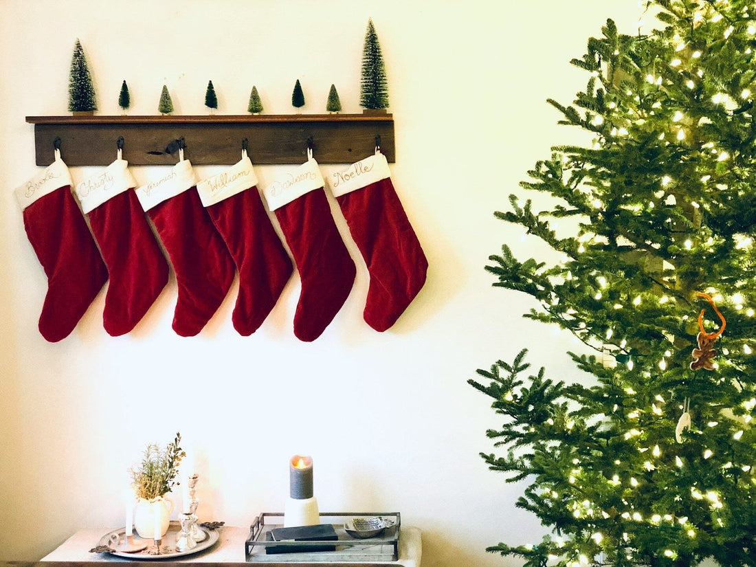 Dark red stockings hung up next to a Christmas tree