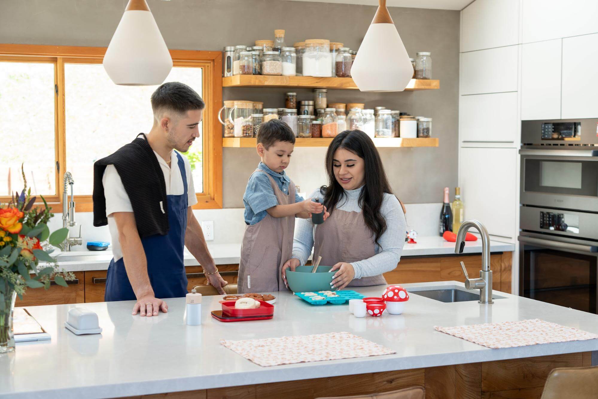 Family of three cooks together in the kitchen