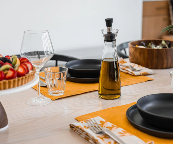 A dining table set with plates, glasses, salad, and tart