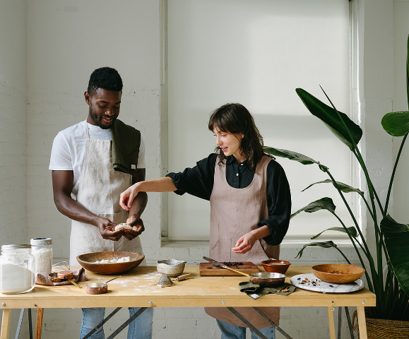 A man and a woman make bake together at a kitchen table