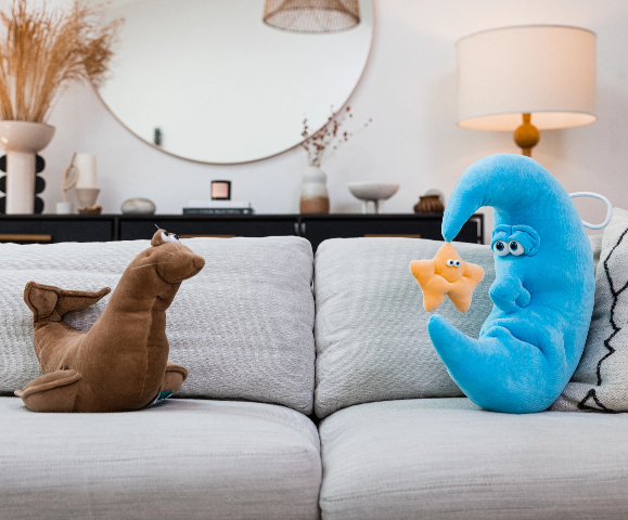 Living room couch with pillows and plush moon and seal